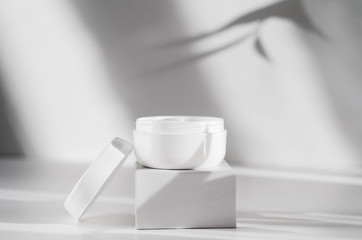 Natural cosmetics, organic cosmetology poster concept with copyspace. Moisturizing balm, facial mask jar. Opened white container with feminine skin care product. Feminine skincare attribute