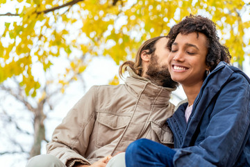 guy with an african american girl in love in autumn park walk at sunset