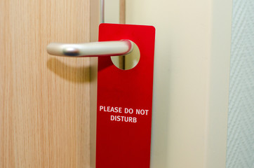 Closed door of hotel room with please do not disturb sign