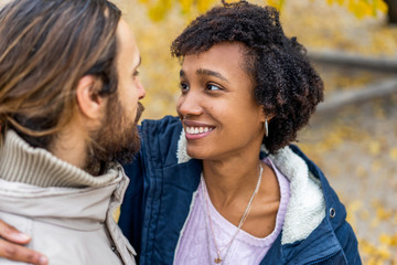 guy with an african american girl in love in autumn park walk at sunset
