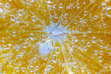 slice of juicy orange is covered with small air bubbles