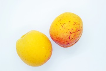 Delicious juicy apricots are located on a white background
