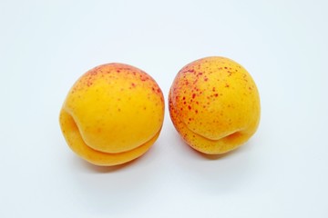 Delicious juicy apricots are located on a white background