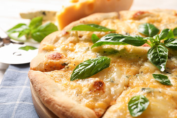 Cheese pieces and pizza with basil on white background, close up
