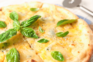 Pizza with basil and cutter on white background, close up