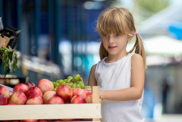 Fototapeta premium Cute Little Girl Choosing Fruits