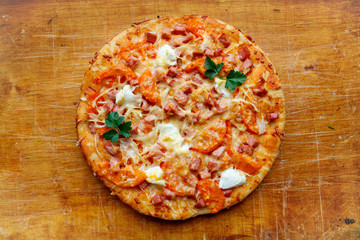 homemade pizza with tomatoes cheese and herbs on the Board