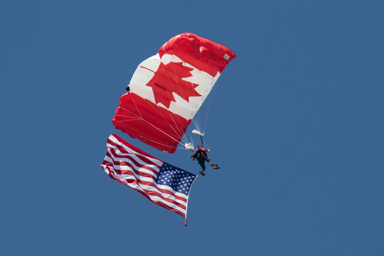 Canadian skydiver carrying American fag - Powered by Adobe