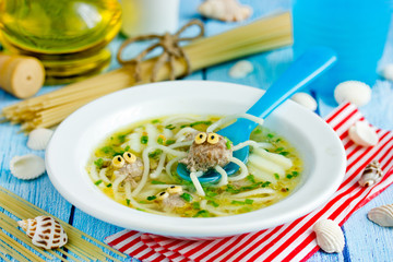 Octopus soup for kids lunch - potato soup with meatballs and spaghetti shaped funny octopuses in white bowl