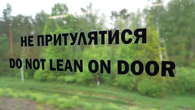 Do not lean on door. Inscription on the window in passenger train