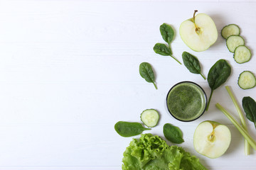 Green smoothie and fresh vegetables on the table for the detox organism top view.