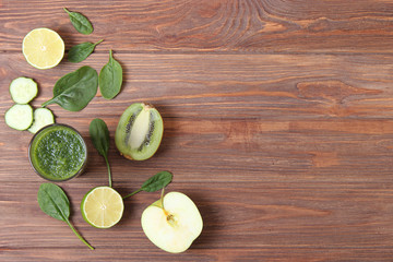 Green smoothie and fresh vegetables on the table for the detox organism top view.