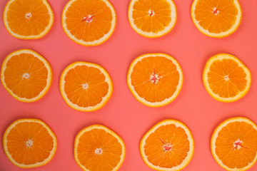 Background of ripe oranges cut on pink background