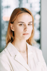 business portrait of a young girl on the background of the office. working situation with a smiling woman.