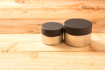 Cosmetic containers on wooden background