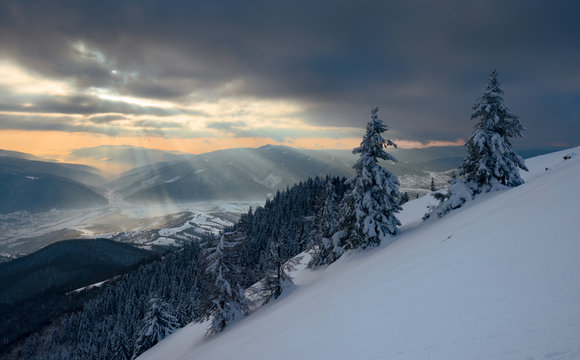Sun rays over the mountain valley in winter
