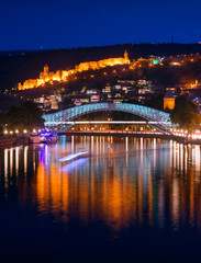 Fototapeta na wymiar Bridge of Peace and Narikala Fortress at night. Tbilisi, Georgia