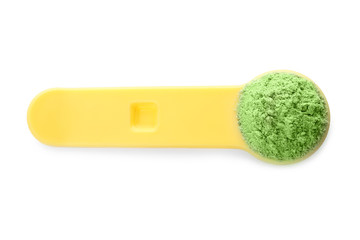 Measuring spoon with wheat grass powder on white background, top view