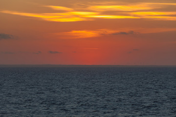 Naklejka premium Orange sky right after sunset behind the italian coast
