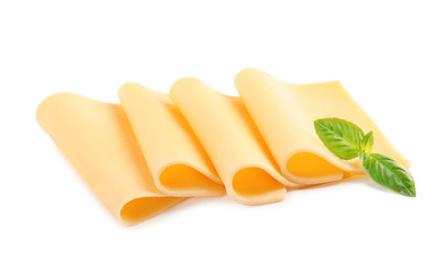 Slices of tasty cheese with basil on white background