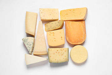 Composition with different kinds of tasty cheese on white background, top view