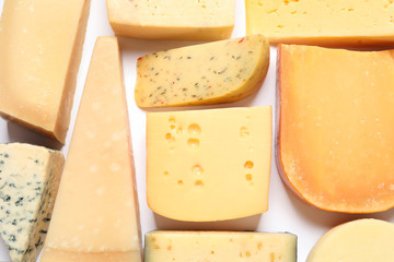 Composition with different kinds of tasty cheese on white background, top view