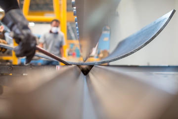 Asian worker in factory at metal workshop - bender