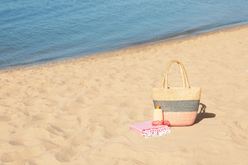 Stylish beach accessories on sand near sea. Space for text