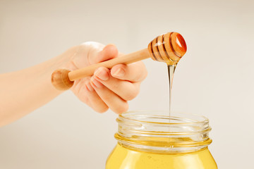 Dipper with honey in woman hand. Space for text or design.