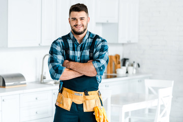 happy bearded man smiling while standing with crossed arms