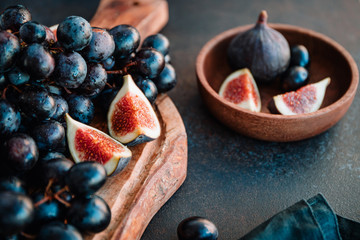 Autumn food still life with season fruits like Bangalore blue grape and figs on a table.