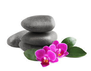 Pile of spa stones and orchid flowers on white background