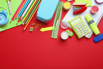 Bright school stationery on red background, flat lay. Space for text