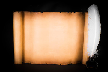 Unrolled scroll of papyrus with a pen on a black background
