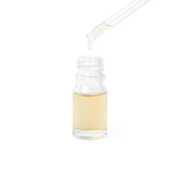 Woman dripping essential oil from pipette into glass bottle on white background