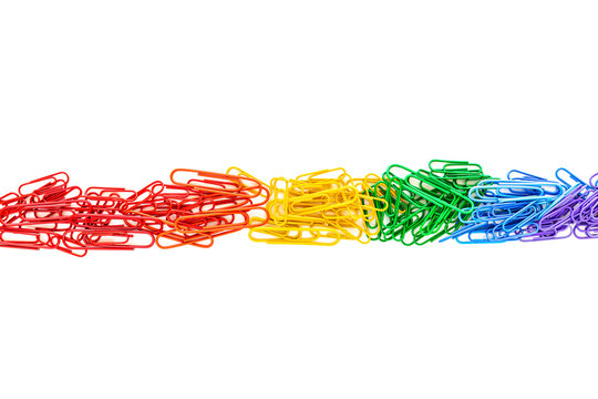 Rainbow colored paperclips on white background as symbol for workplace diversity, gay pride