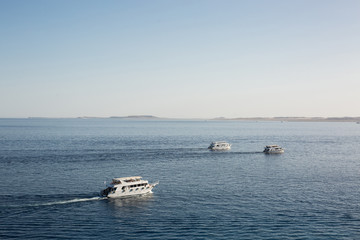 Pleasure boats return to port at sunset. Ships with tourists on diving excursions in the Red Sea. Near Tiran Island, Egypt. popular Marine excursion aerial view