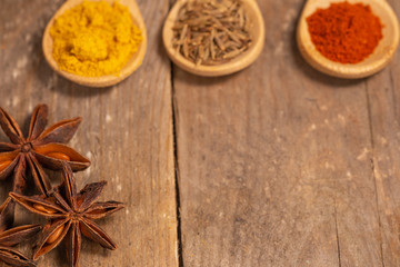 close up view of an assortment of spices on a rustic table with negative space