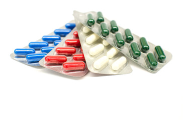 multicolored capsules in a blisters in a white background