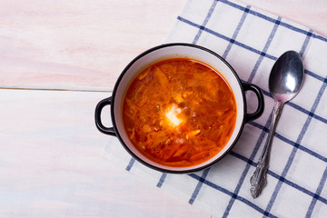 bowl with traditional borscht (beetroot soup) on white table.