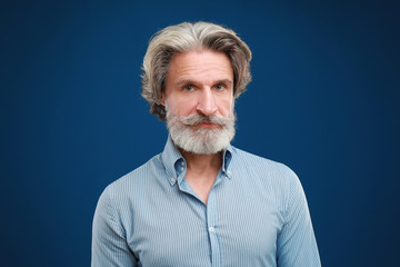 Obraz premium Portrait of handsome mature man on blue background