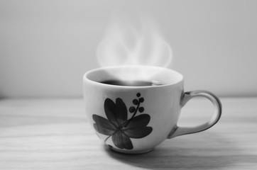 Floral coffee cup with smoke placed on a black and white style wooden floor