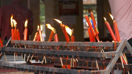 Video 4k of flame from burning red chinese candle in the temple