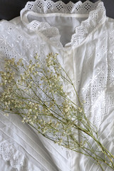 Vintage white lace blouse and gypsophila flowers. Top view.