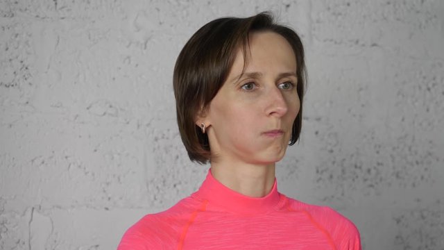 Young woman puffing out cheeks while face yoga on white background. Woman training facial gymnastics for lifting skin. Face skin care. Mimic gymnastic exercises