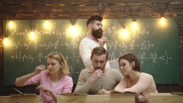 Group Of Students Collaborating On Project In Classroom With Inteligent Teacher. Education, school, college and university concept. Teacher creates sense of community and belonging in classroom.