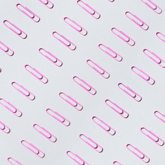 Pink paper clips on pastel grey background. Top view, flat lay. Back to school concept. College, institute education, office work