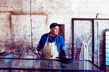 Worker welding metal at workshop