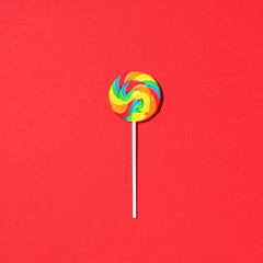 Colorful lollipop on red background. Top view. Flat lay. Minimal summer concept. Sugar rush