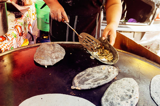 Close up view of stuffing buckwheat taco using spatula while baking